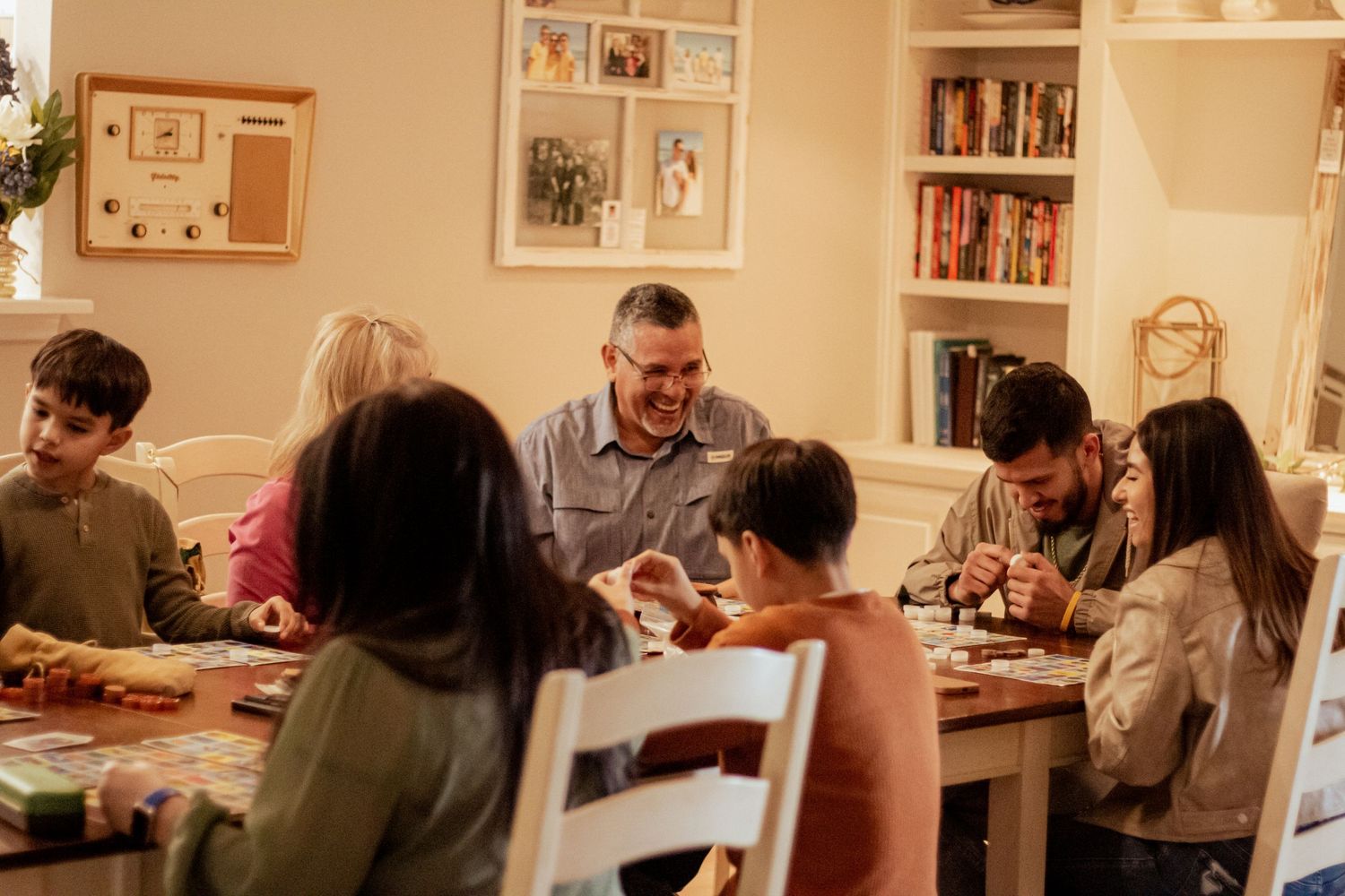 People gathered around a dining table enjoying a meal together in a cozy home setting.