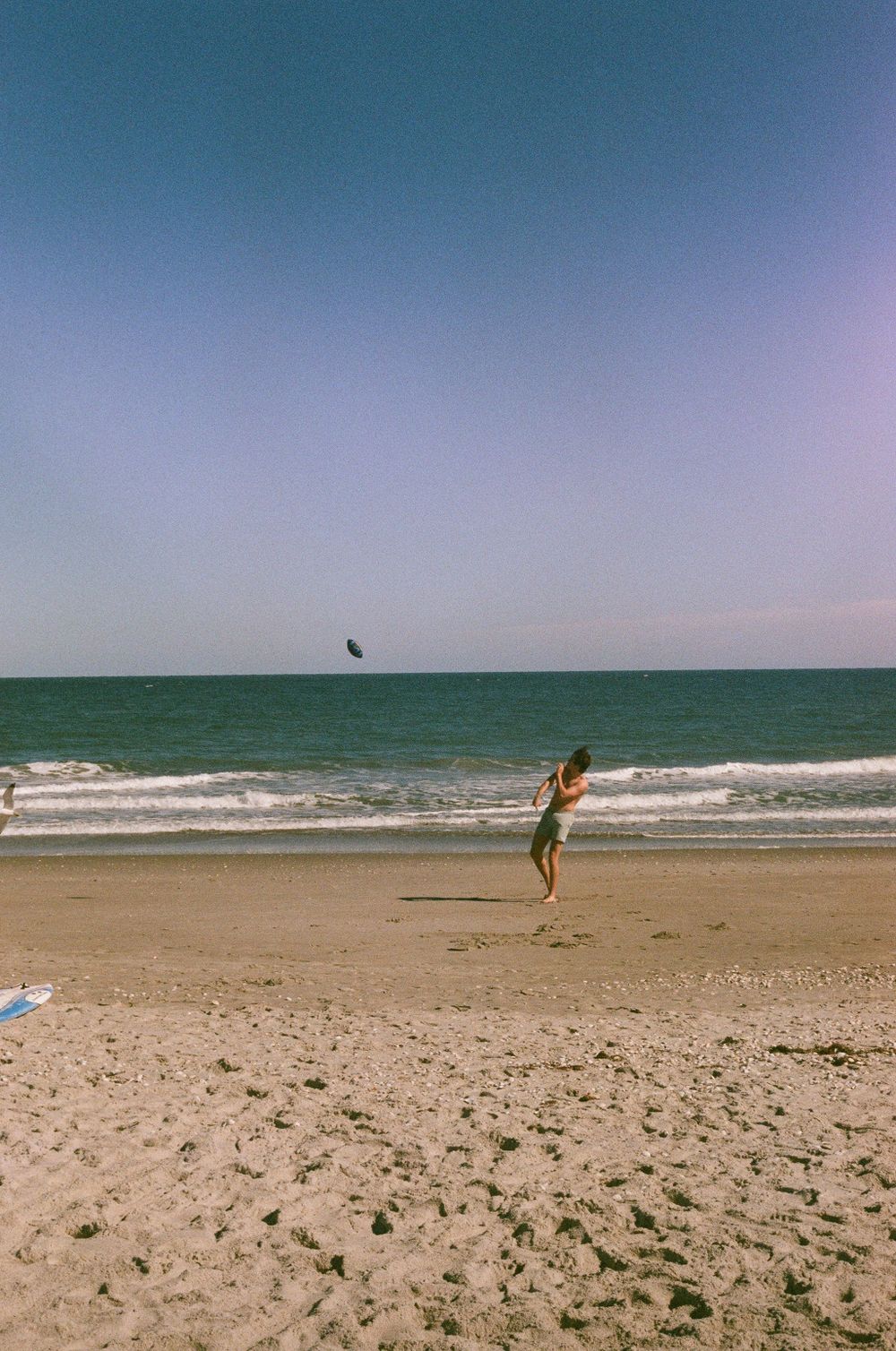 Candid shot of a kid throwing a football on the beach in Florida on film