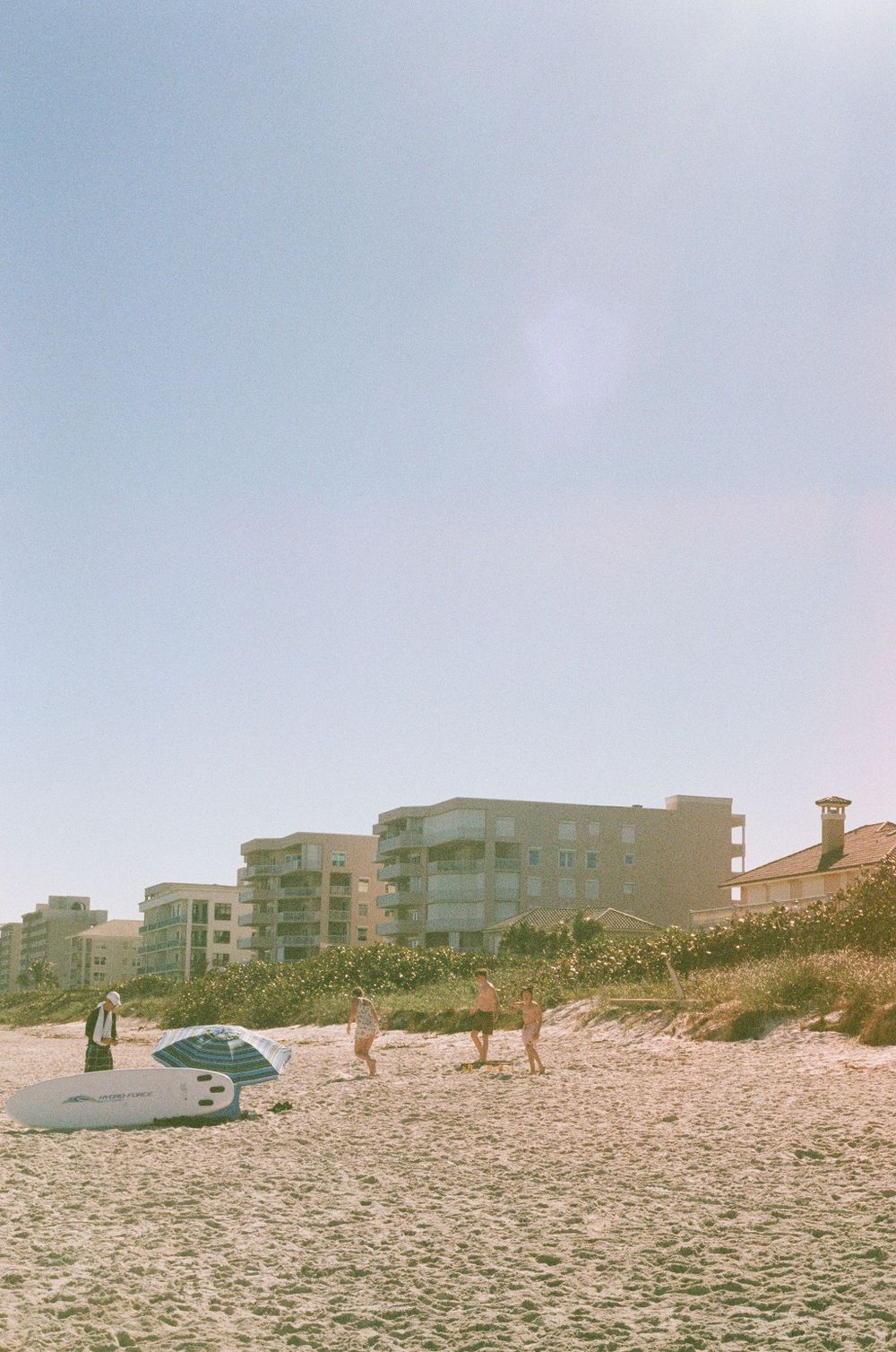 Some candid moments of people walking on a beach in Florida on film