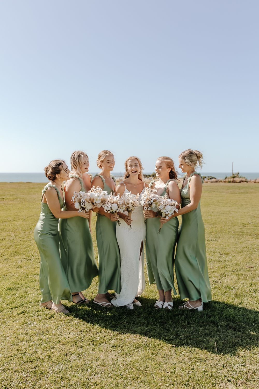 Bride with her bridesmaids sharing a candid laugh during a West Coast NZ wedding