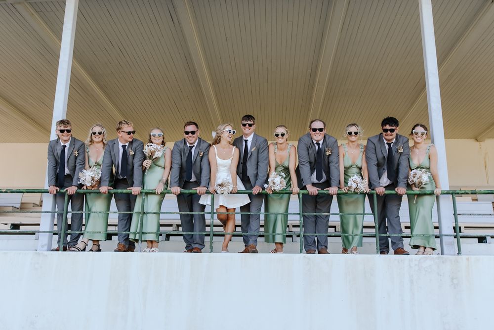 Playful wedding party moment with bride and groom surrounded by friends in New Zealand