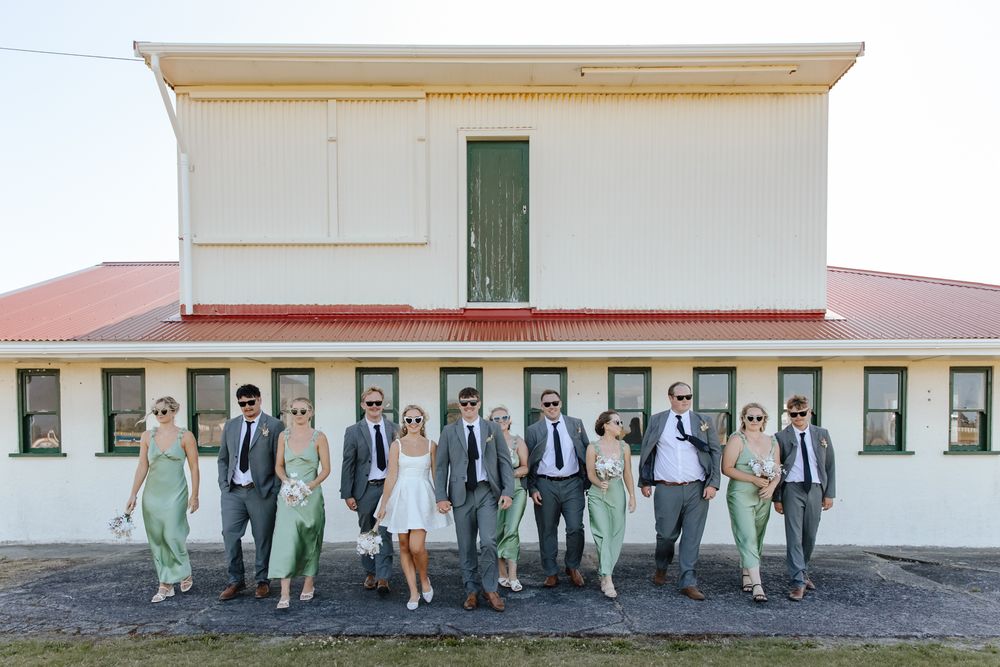 Playful wedding party moment with bride and groom surrounded by friends on the west coast in New Zealand