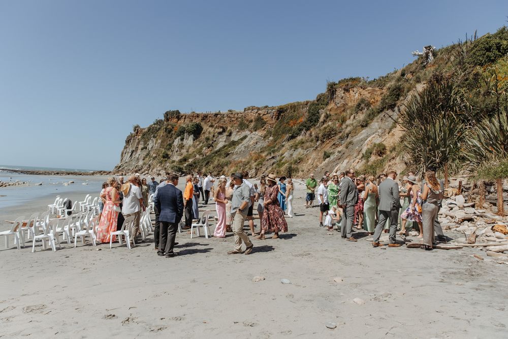 Fun candid moment of wedding guests on a West Coast NZ beach wedding