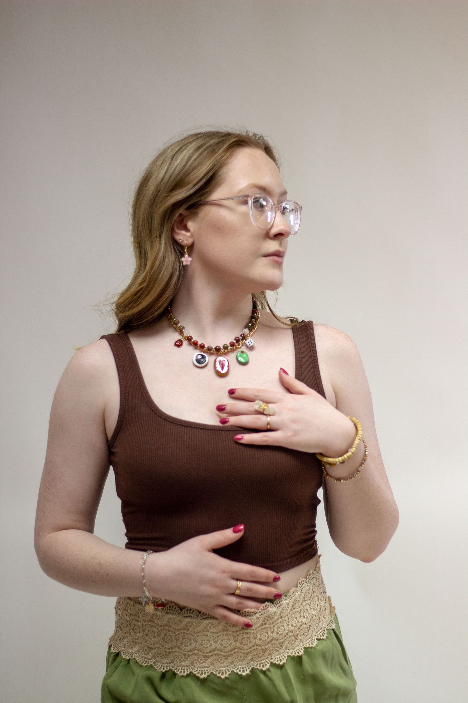 A series of photos showing someone wearing a brown tank top and green skirt with lace trim detail.