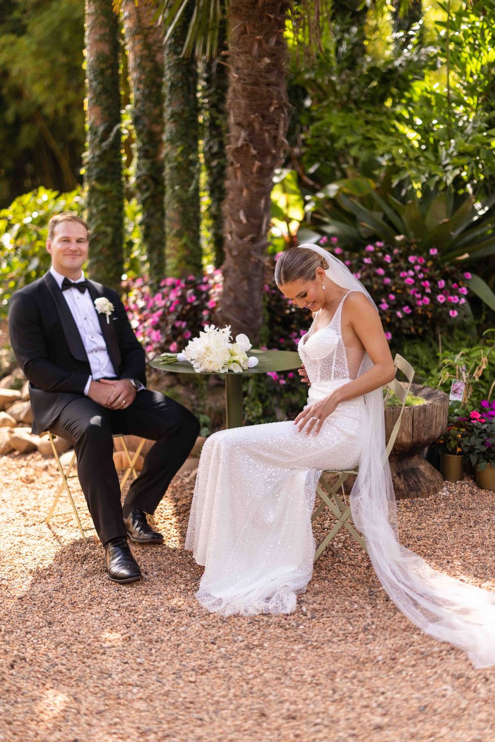 A romantic wedding photo sequence shows a couple playfully posing on mulch ground surrounded by pink flowers and trees.