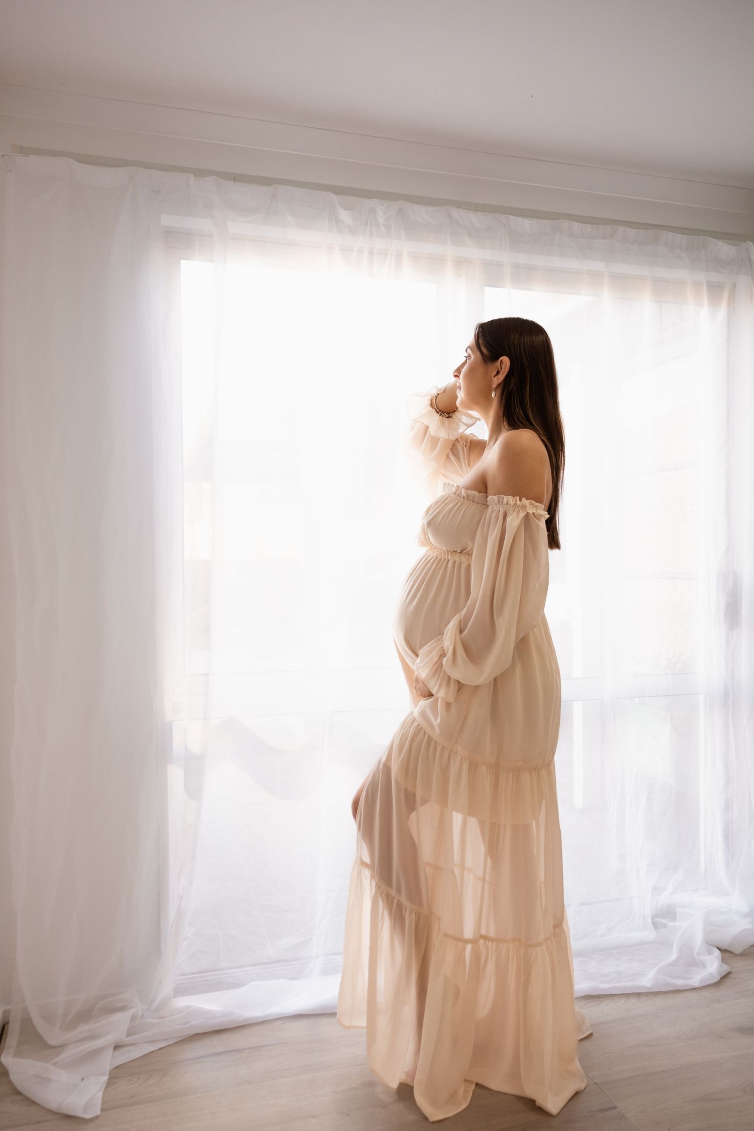 Pregnant mother holding bump near caves during maternity photoshoot
