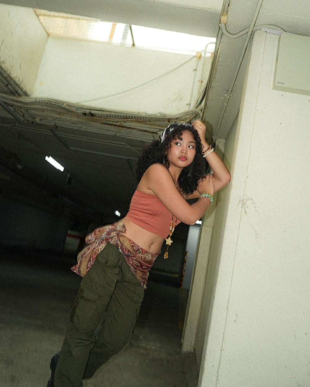 Stylish indoor fashion photography in an industrial setting with dramatic lighting.