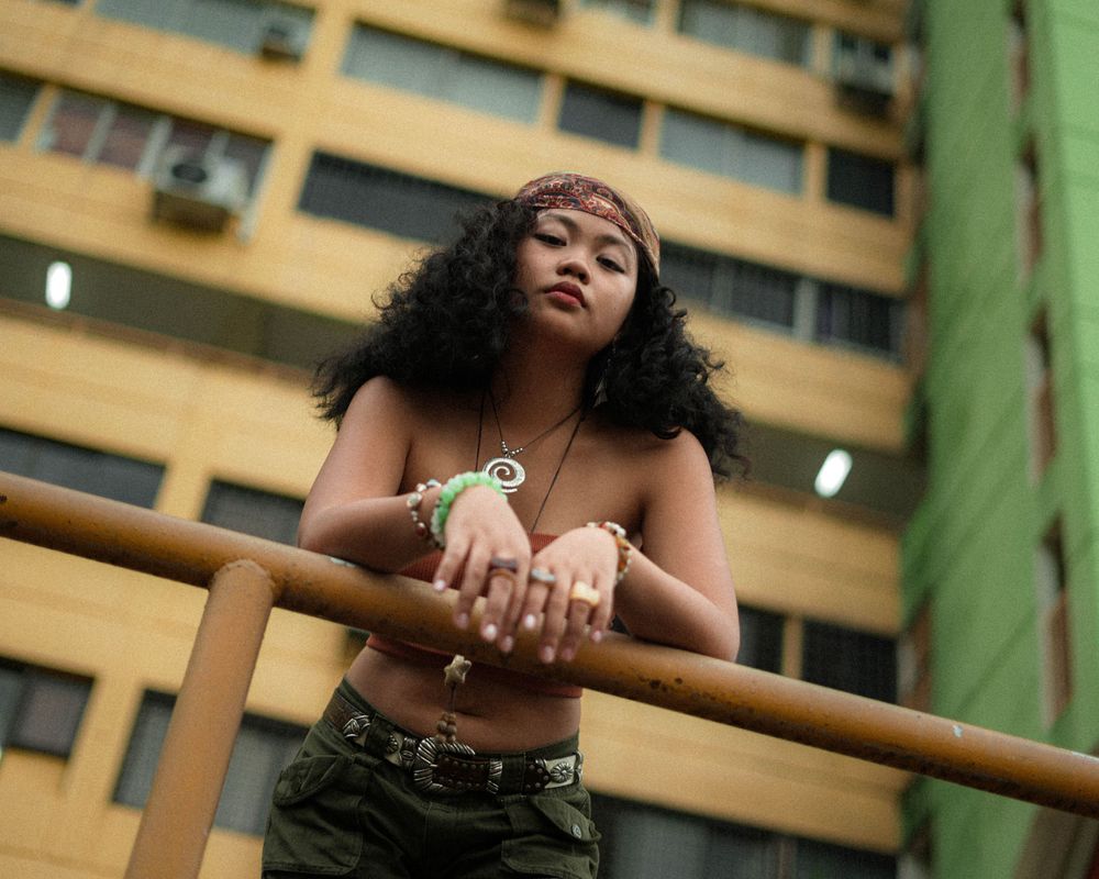 Urban fashion portrait taken against colorful residential buildings.