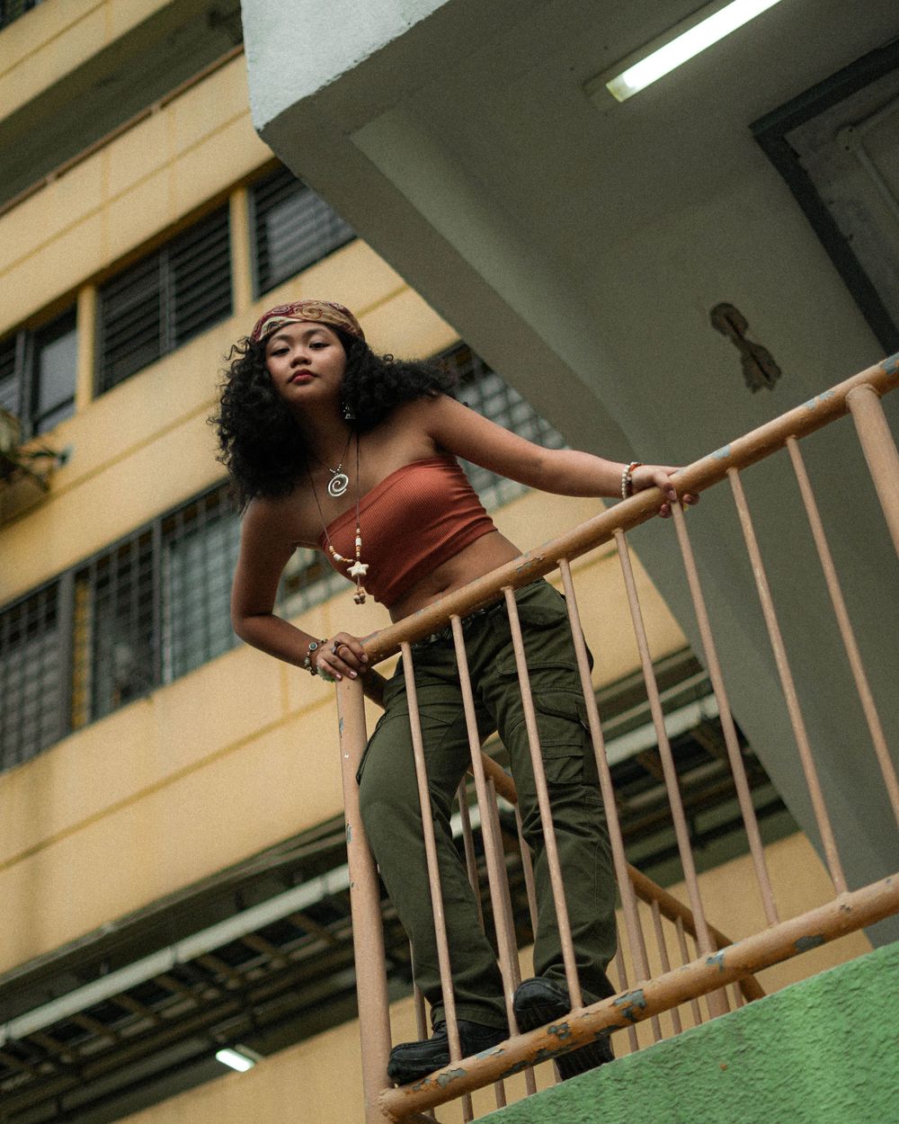 Fashion portrait on residential building staircase with urban architectural elements.