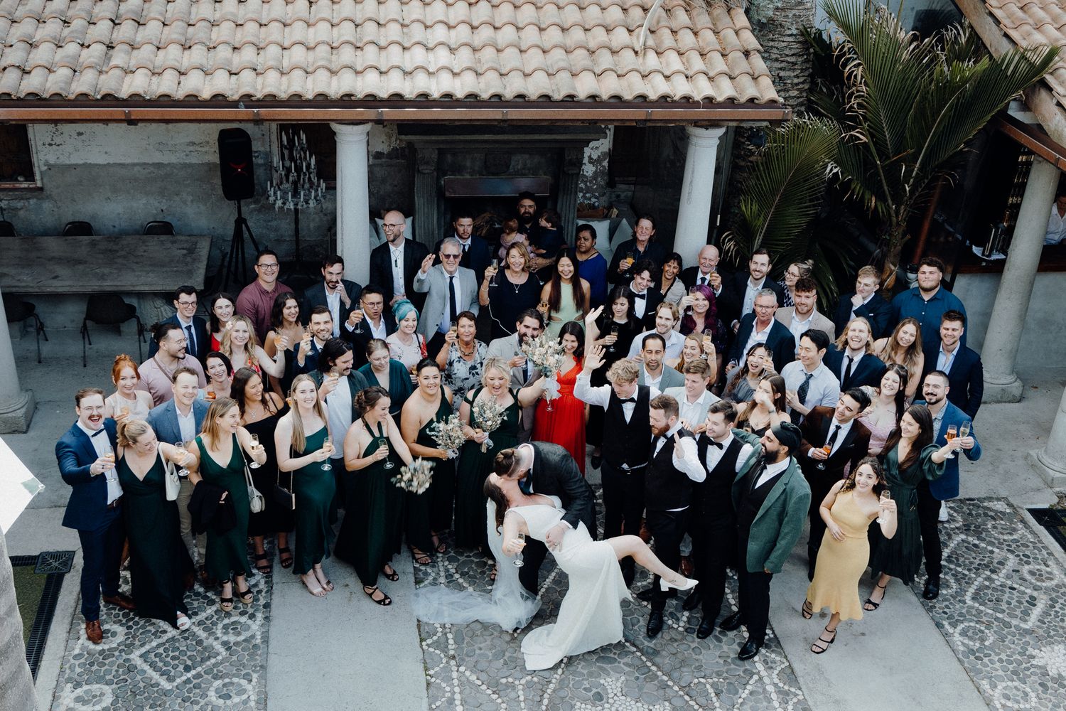 The groom kissed the bride for their group photos with the wedding guests, captured by Apertured Media Auckland Wedding Photographer.