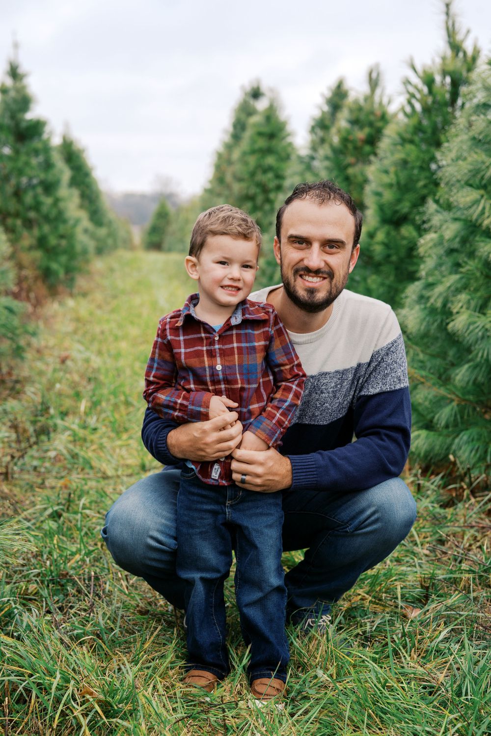 Candid moments captured between two people sitting in a Christmas tree farm.