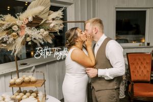 Wedding couple sharing romantic moment near dessert table with pampas grass decoration.