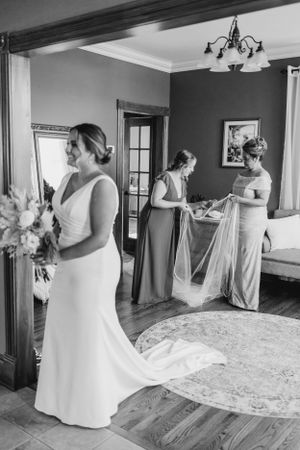 Wedding preparations in an elegant room with vintage decor and hardwood floors.