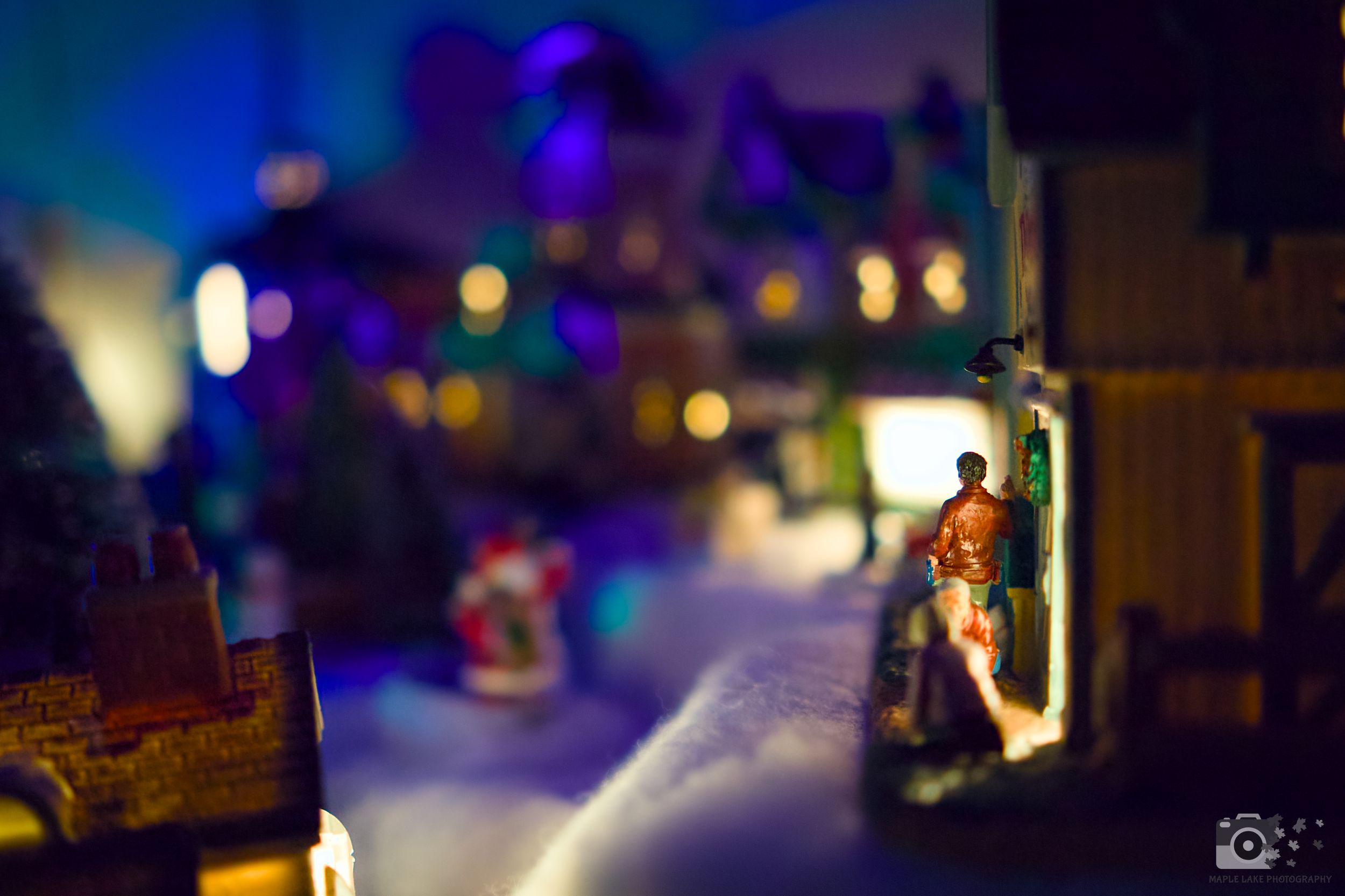 Miniature town scene with colorful bokeh lights in the background.