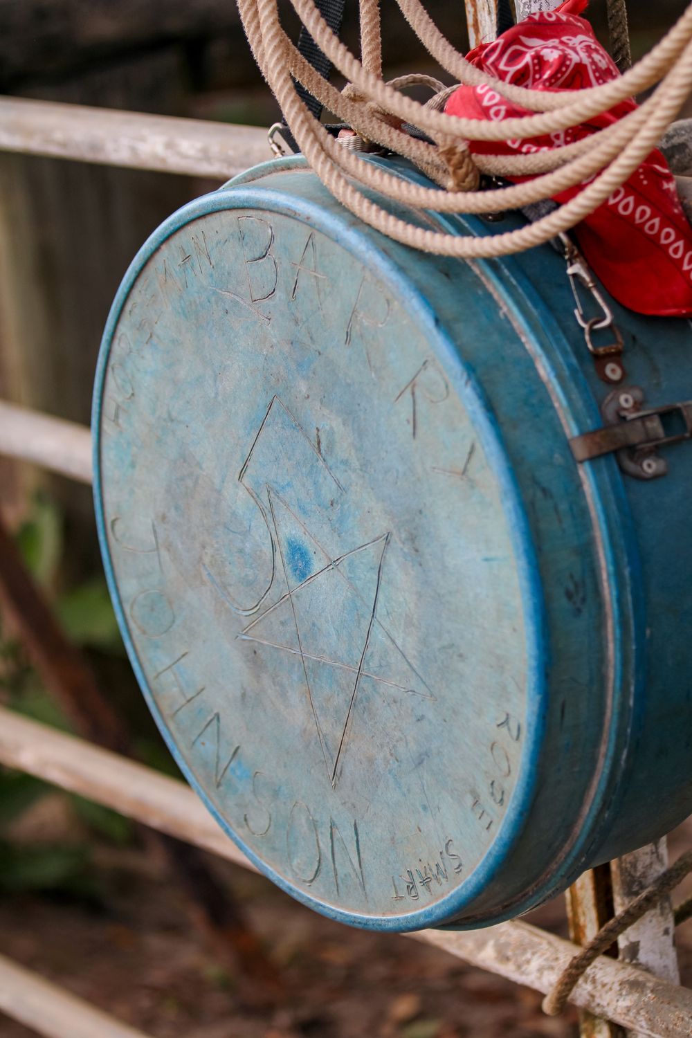 Close-up view of a dusty blue rope case with rope attached at a rodeo.