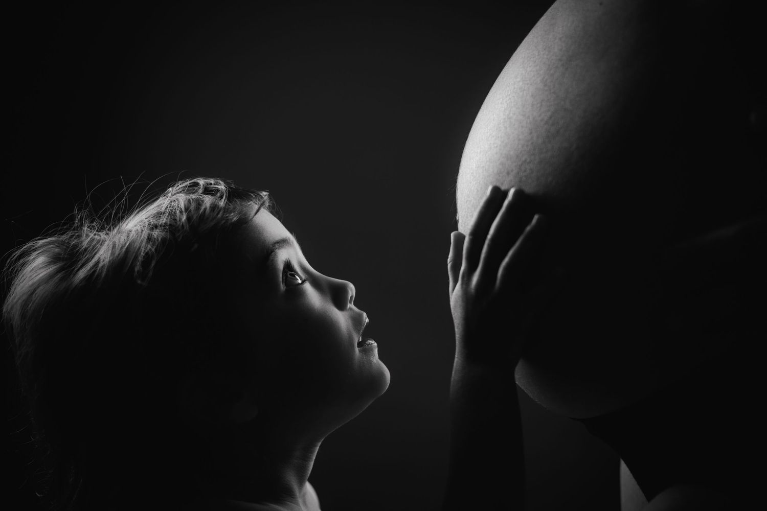 Grossesse émotionnelle en Charente-Maritime - Enfant regardant le ventre rond de sa maman.