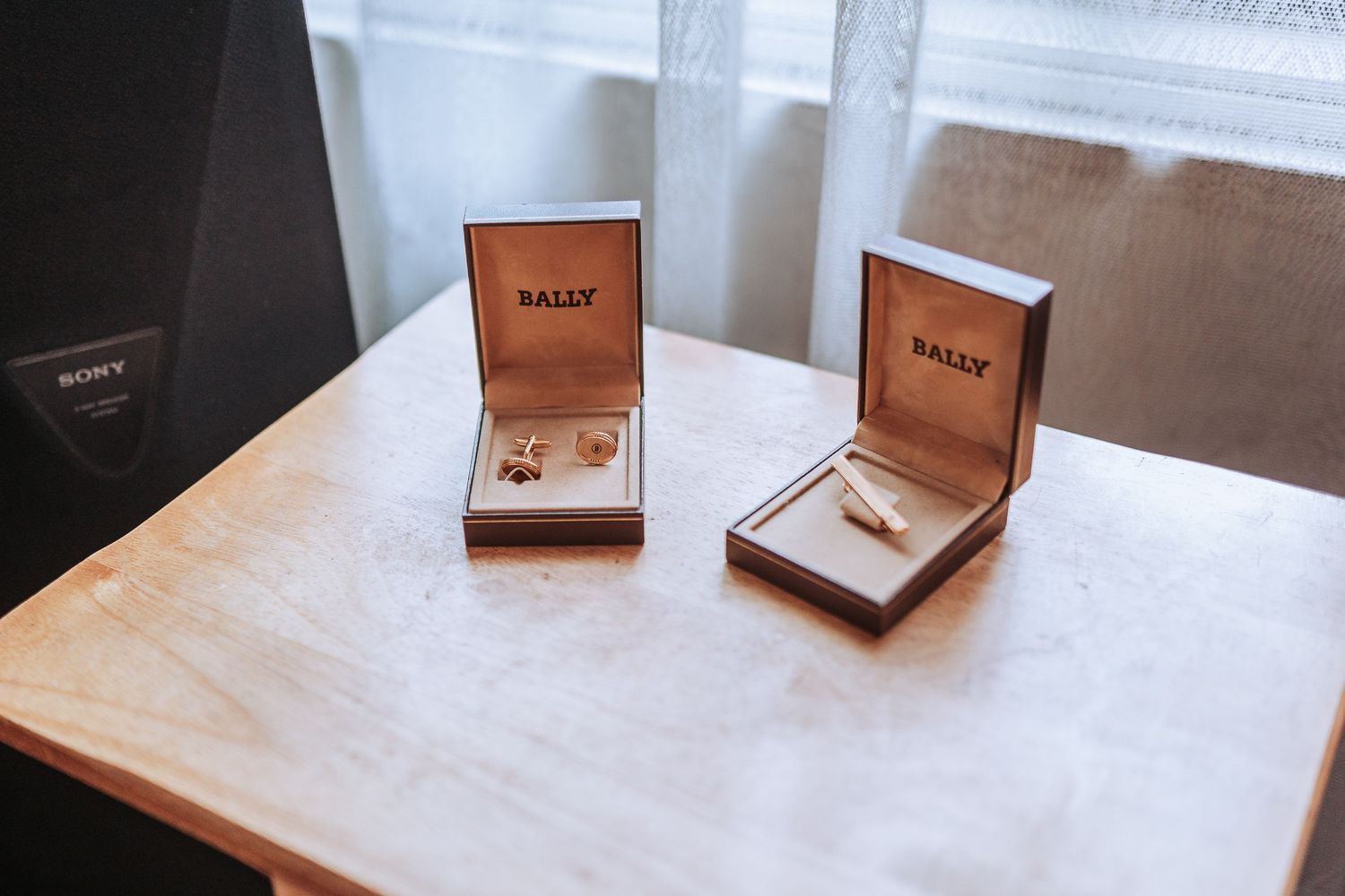 Two wedding rings displayed in luxurious Macy's jewelry boxes on a wooden surface.