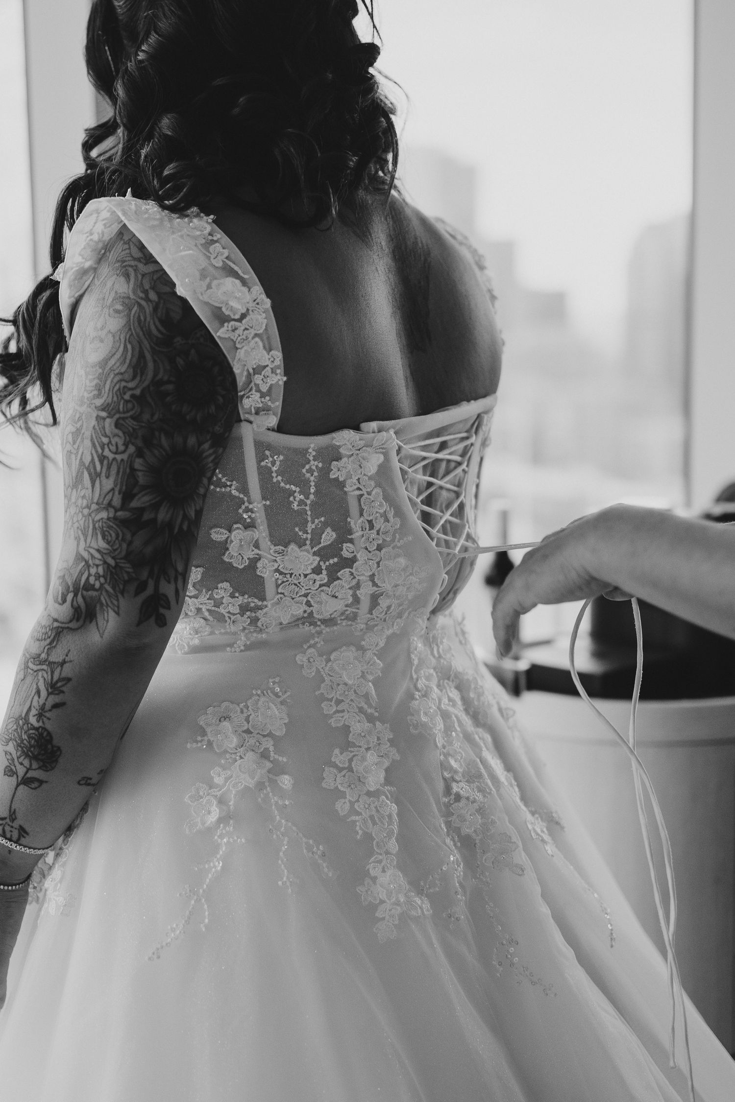 Black and white detail shot of wedding dress corset back with lace and ribbon.