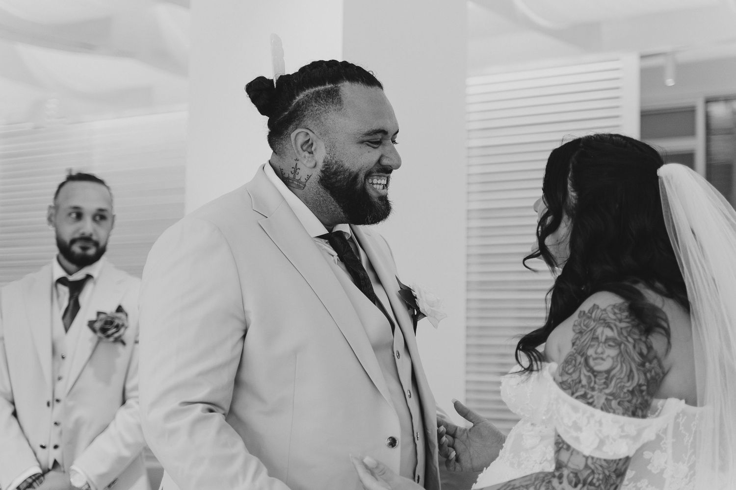 Black and white candid shot of emotional wedding ceremony exchange.