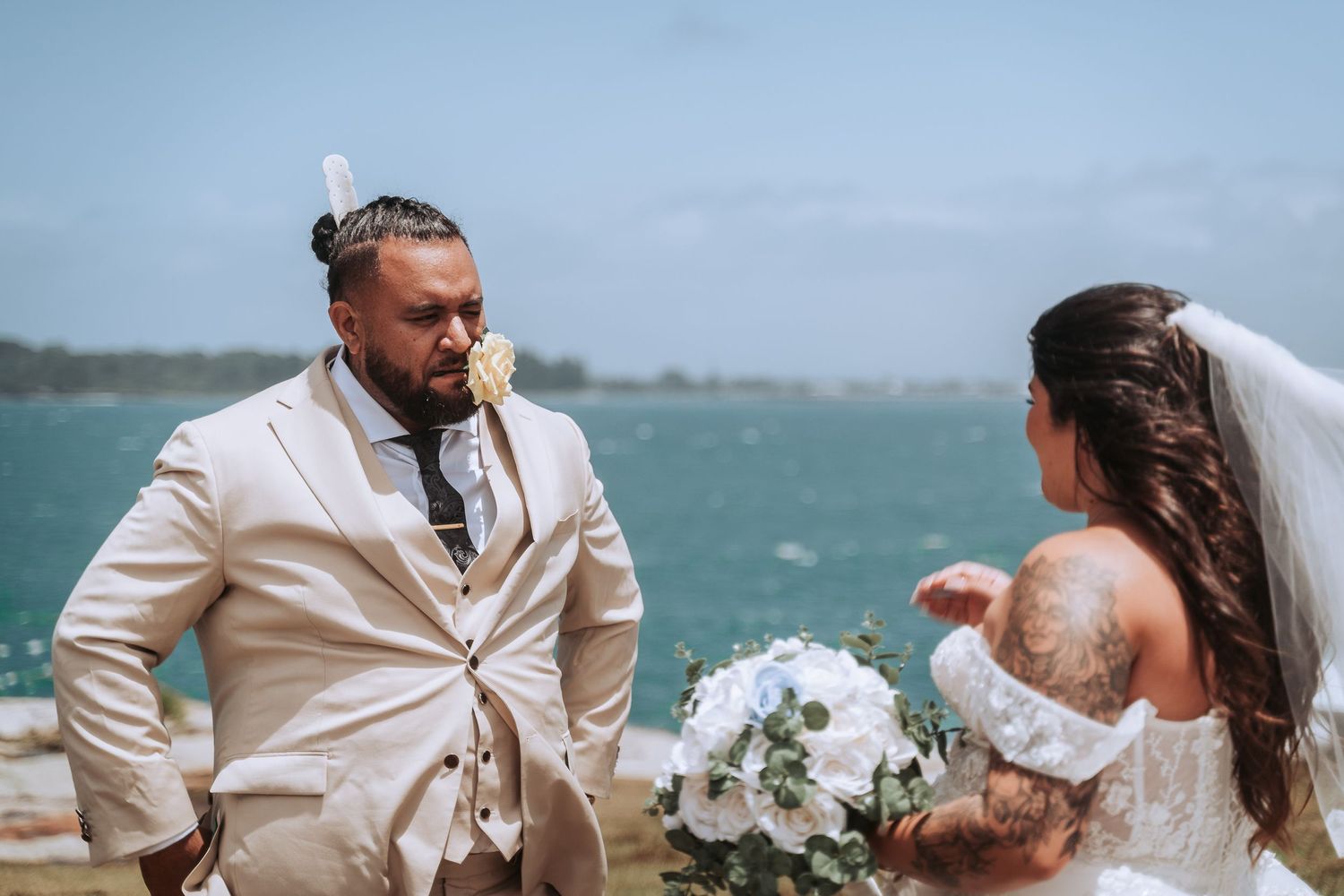 Couple sharing moment during outdoor coastal wedding ceremony with ocean view.