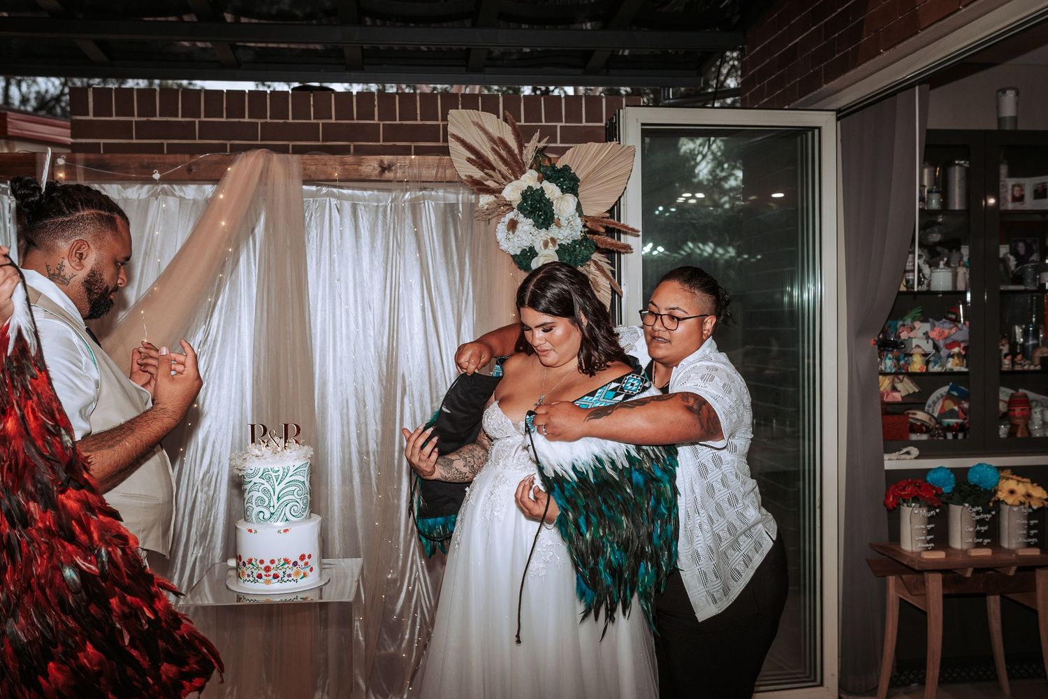 Wedding celebration with guests dancing and celebrating around the newlyweds at an indoor reception.