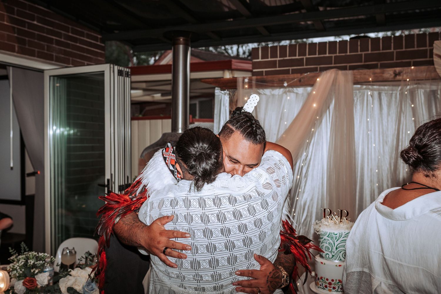 Wedding guests embrace in celebration during reception dancing.