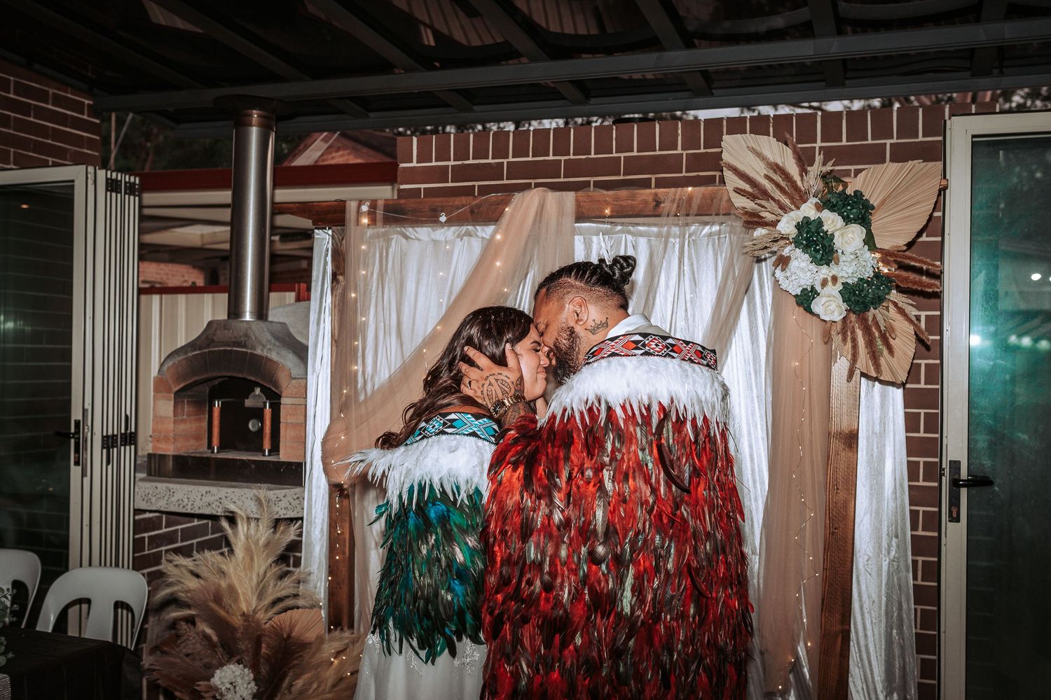 Intimate dance moment during wedding reception with decorative backdrop and mood lighting.