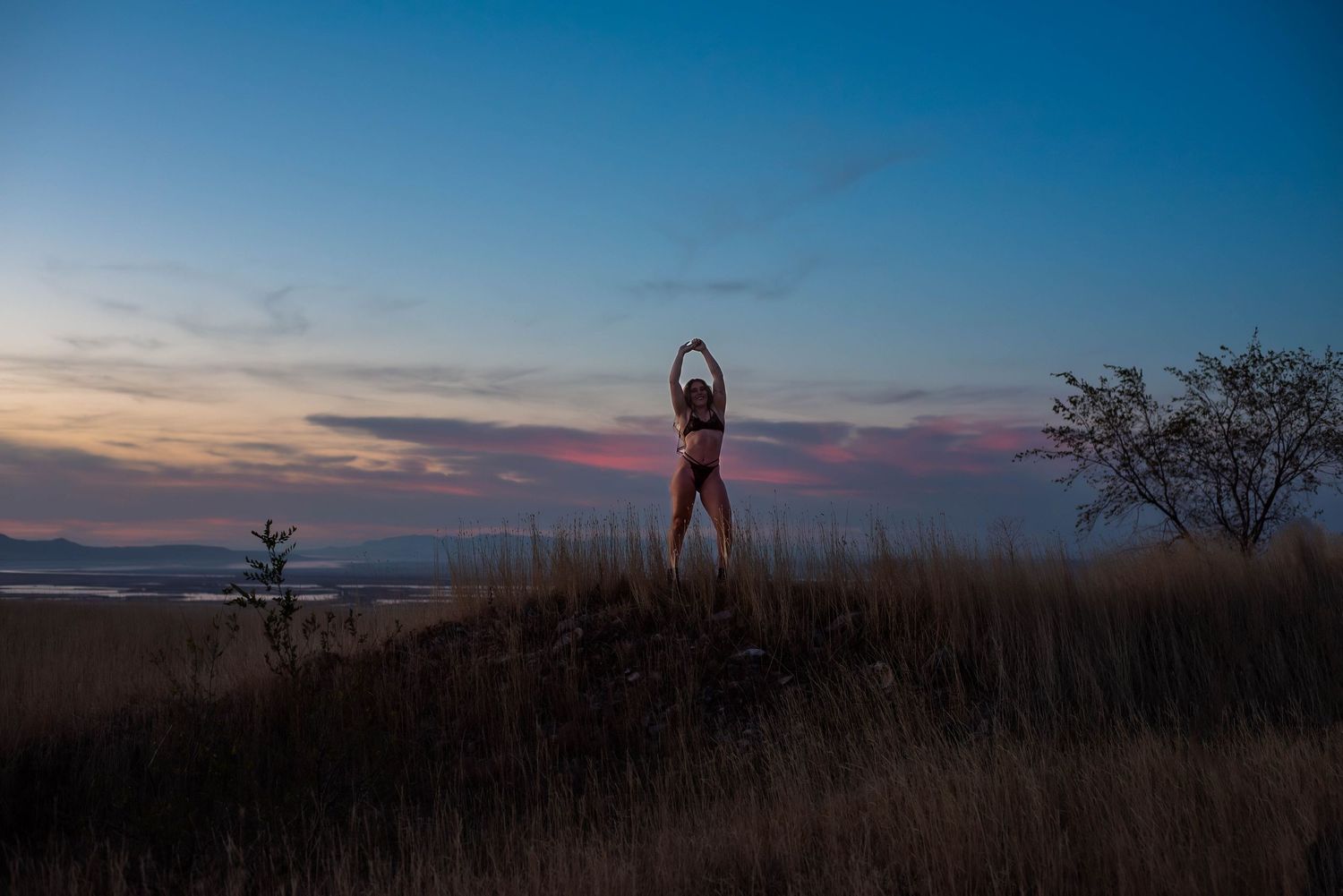 Boudoir photography of a colorful  night sky and a woman silhouette in a field in Salt Lake Utah
