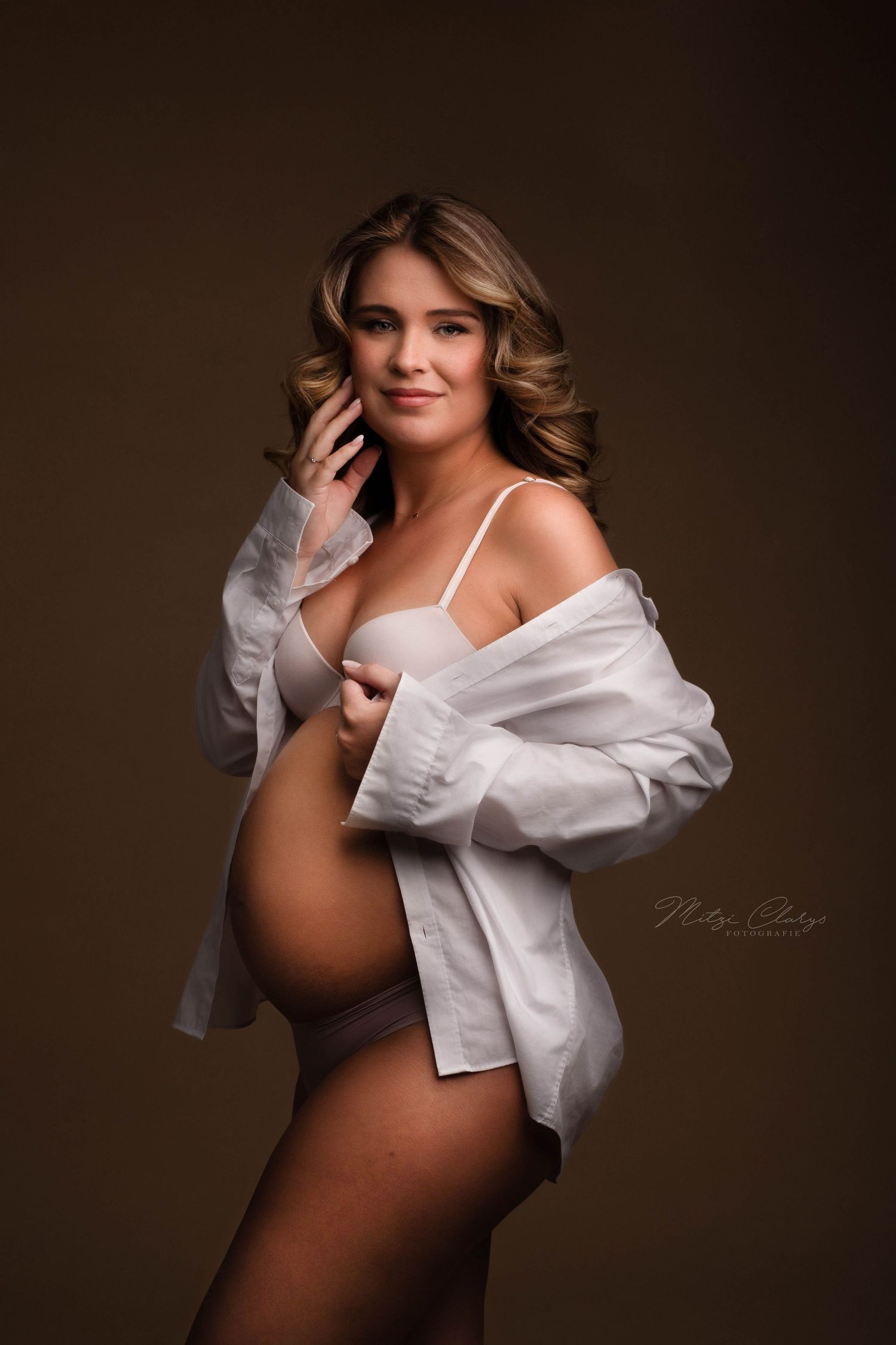 Zwangere vrouw met wit overhemd tijdens fotoshoot in Zeeland