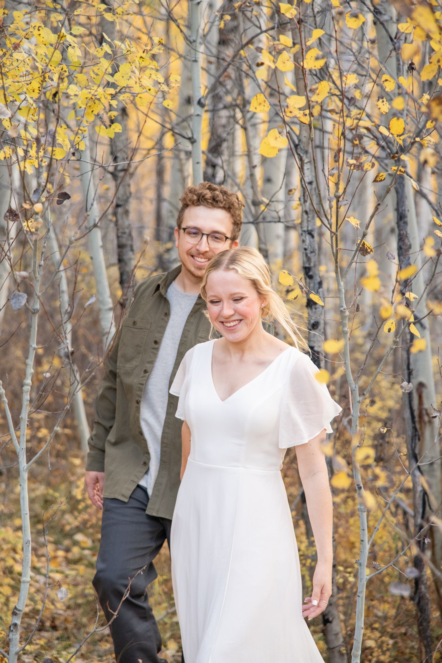 cute candid moment with couple during Vail Colorado engagement photos with golden aspen leaves and trees around them