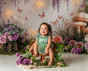 Whimsical garden setup with butterflies and purple flowers for child photography.