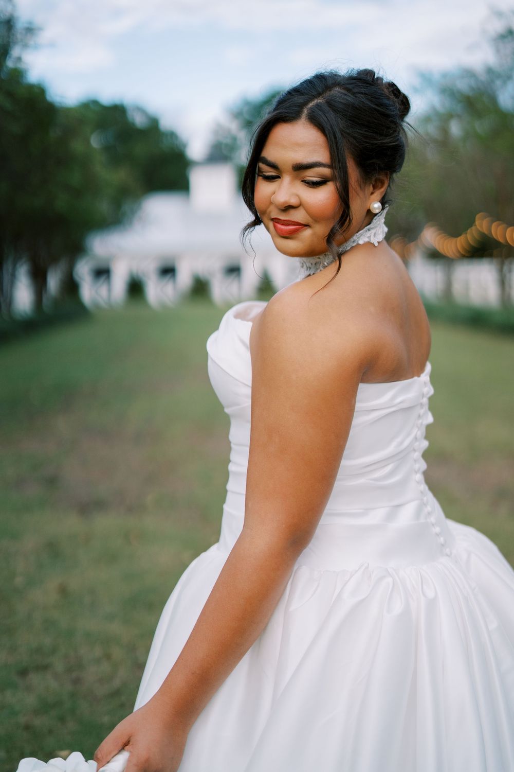 A bride in a white wedding dress poses outdoors in a series of romantic bridal portraits in a natural setting.