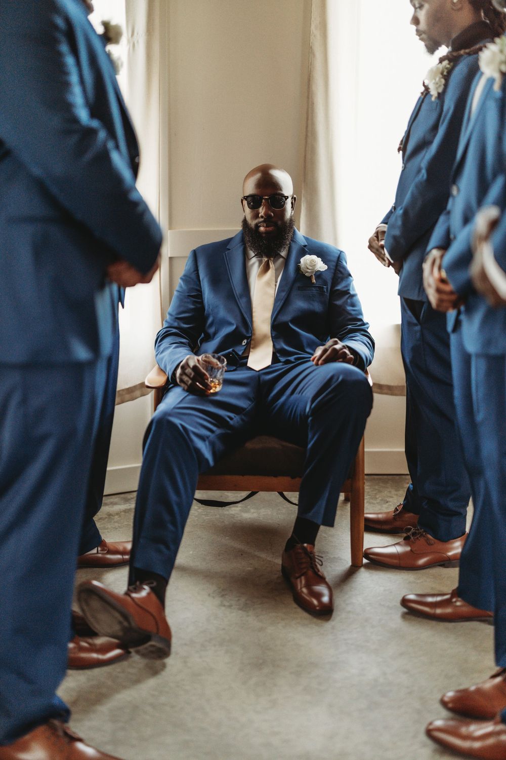 Detail shots of navy blue suits and brown leather shoes during wedding preparations.