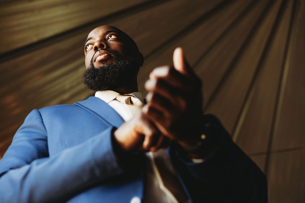 Artistic close-up shots of wedding party members in blue suits with dramatic lighting.