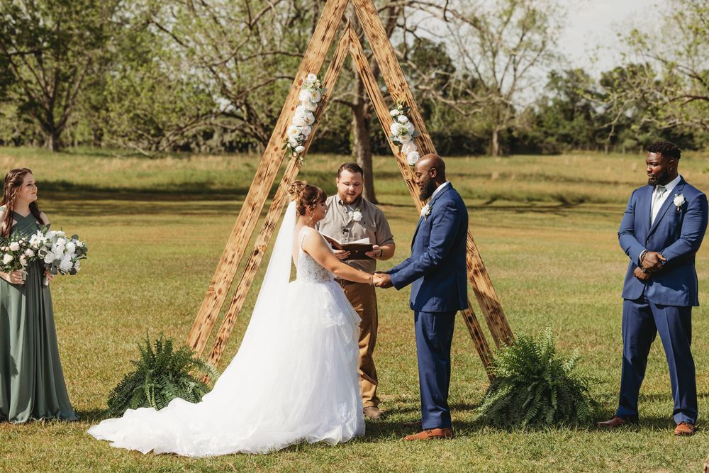 Wedding ceremony setup outdoors with wooden ladder arch and white decor.