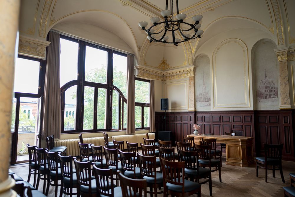 Trauzimmer im Standesamt Friedrichshagen mit hellen Wänden, Holzvertäfelung und großen Fenstern.