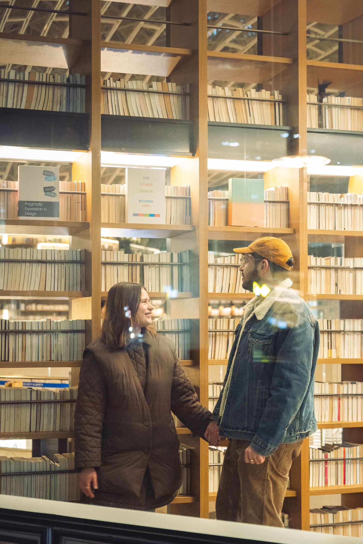 People wearing masks browse through shelves of vinyl records and CDs in a music library.