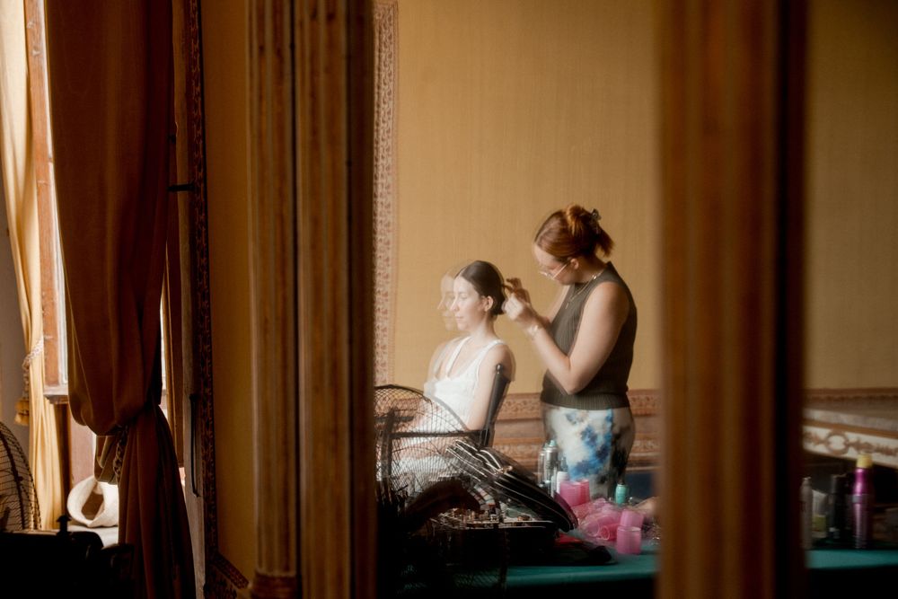 Warm-toned interior scene showing wedding preparations through doorways.