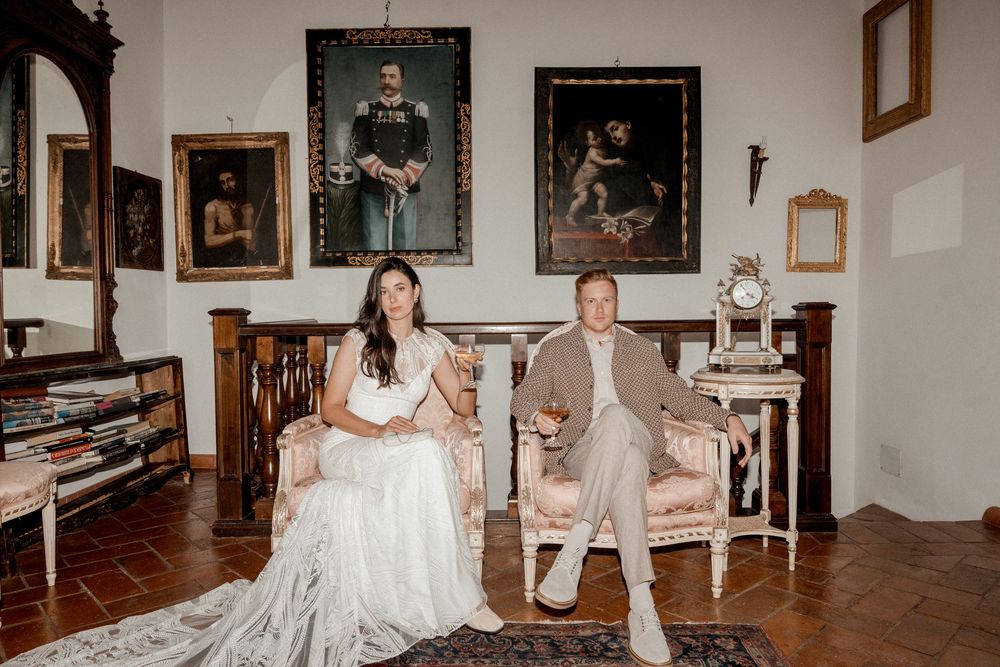 Wedding celebration scene in vintage-style room with antique furniture and framed artwork.