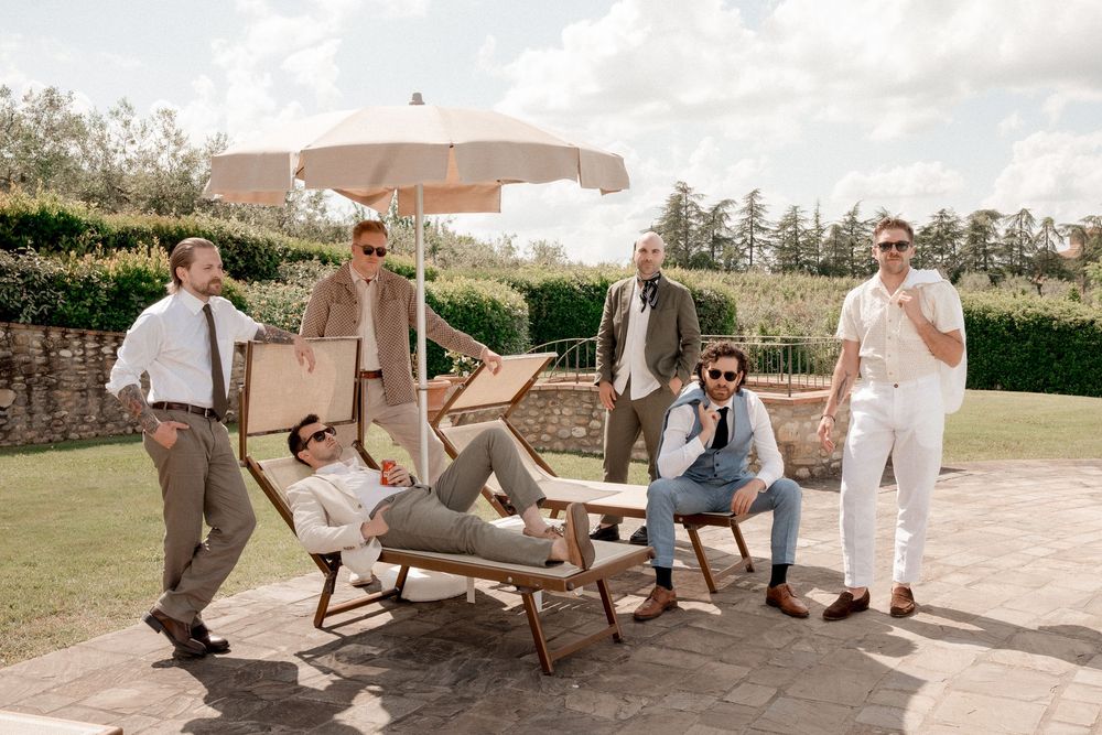 Wedding party relaxing on outdoor furniture in casual candid moments.