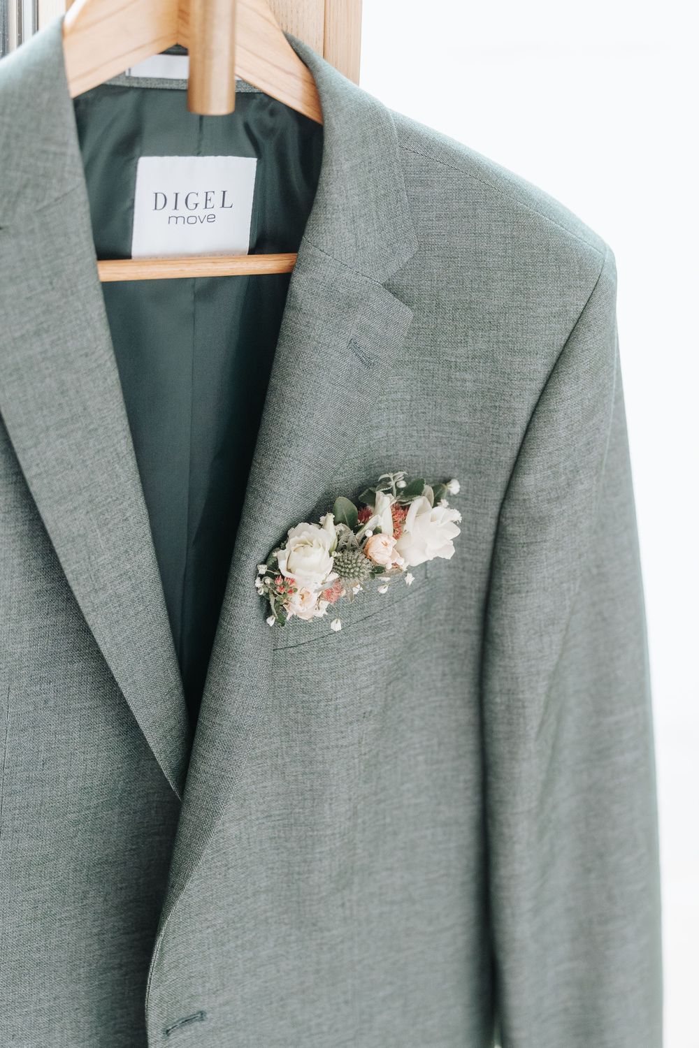 Close-up views of a gray suit jacket with a delicate pink and white floral boutonniere on the lapel.