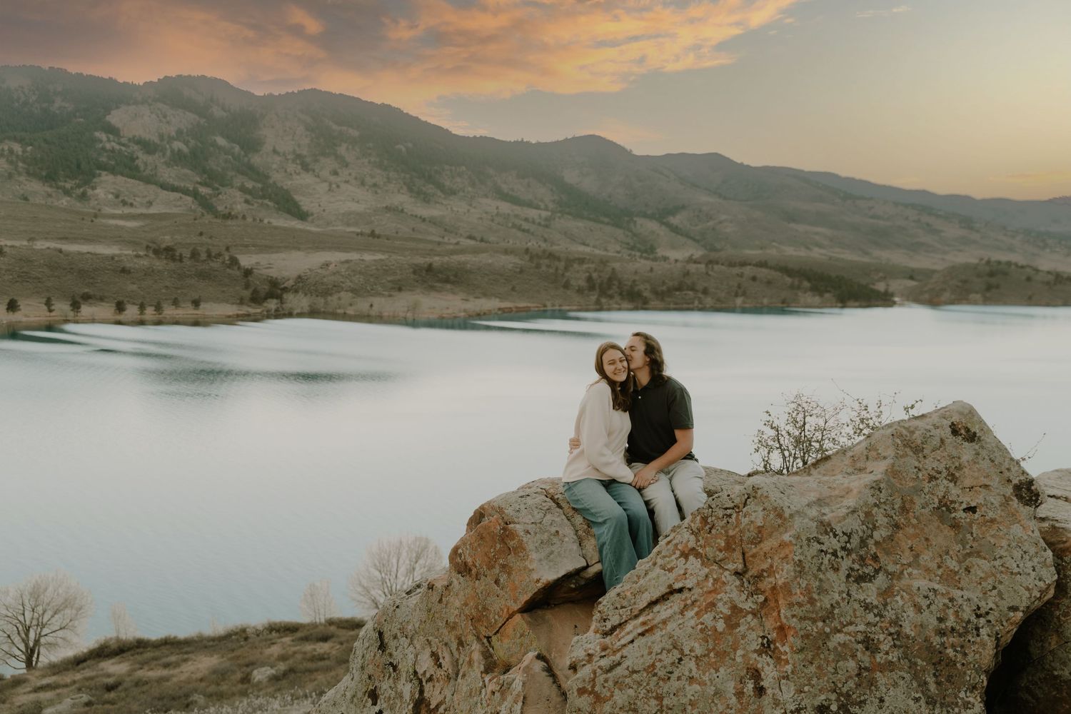 Couple sits and embraces each other for candid couples, engagement photos, sunset, elopement, cinematic photos in Fort Collins, Colorado