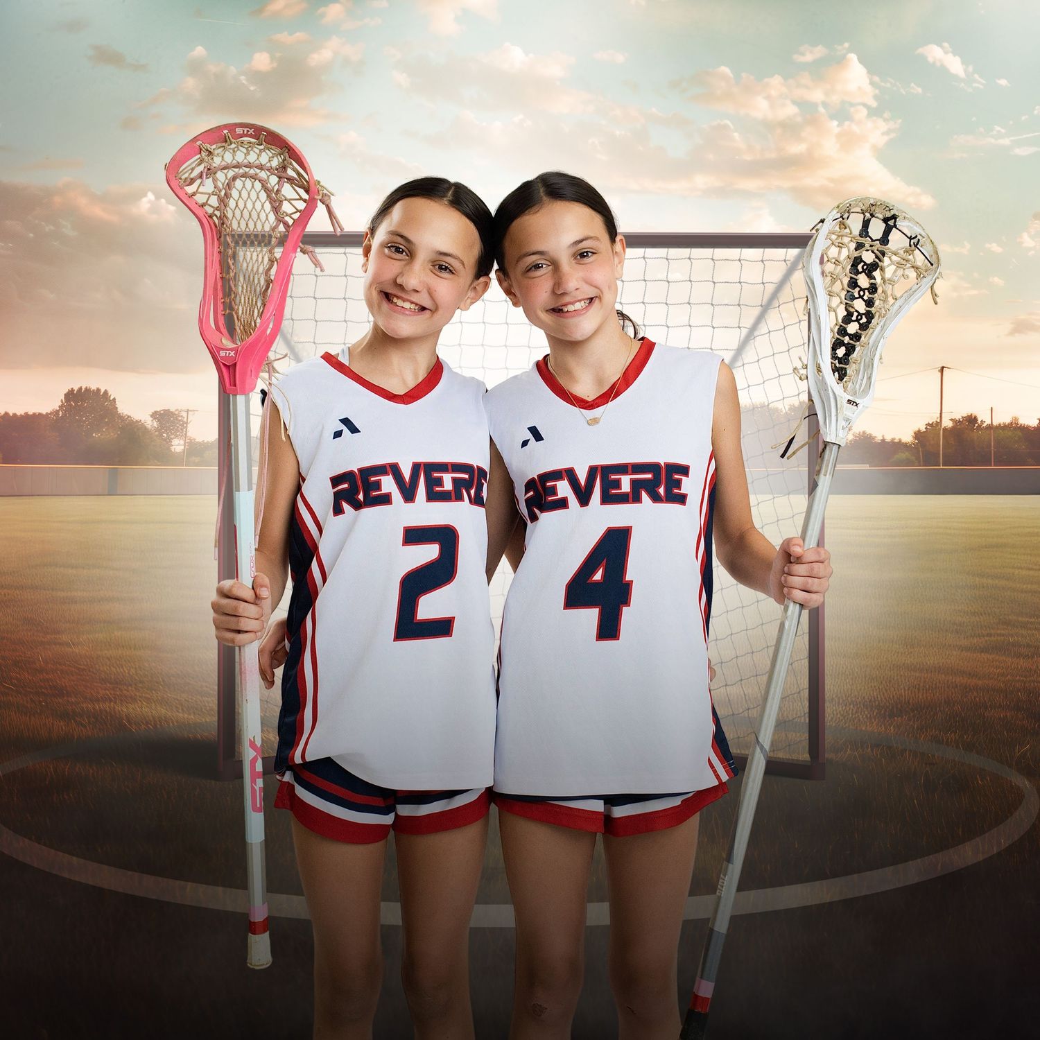 Two Revere lacrosse players in white jerseys numbered 2 and 4 pose with lacrosse sticks on a field.