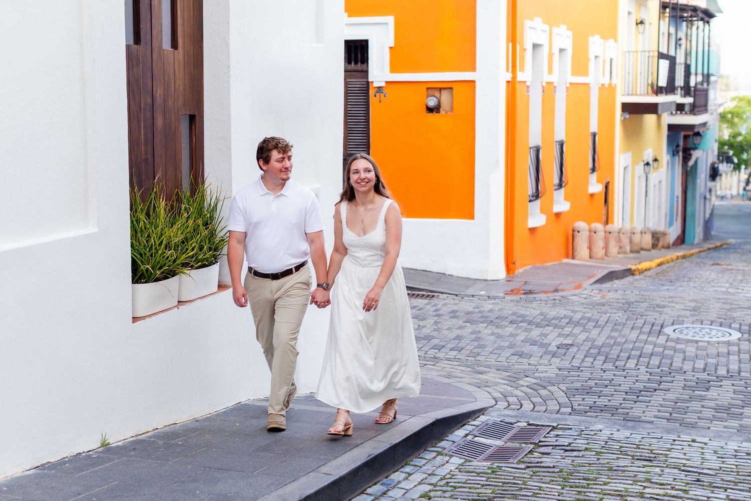 Man and woman walking hand in hand. Engagement photo session in Old San Juan, Puerto Rico.