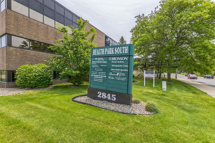 Health Park South medical office building at 2845, featuring a green lawn and professional signage surrounded by lush trees.