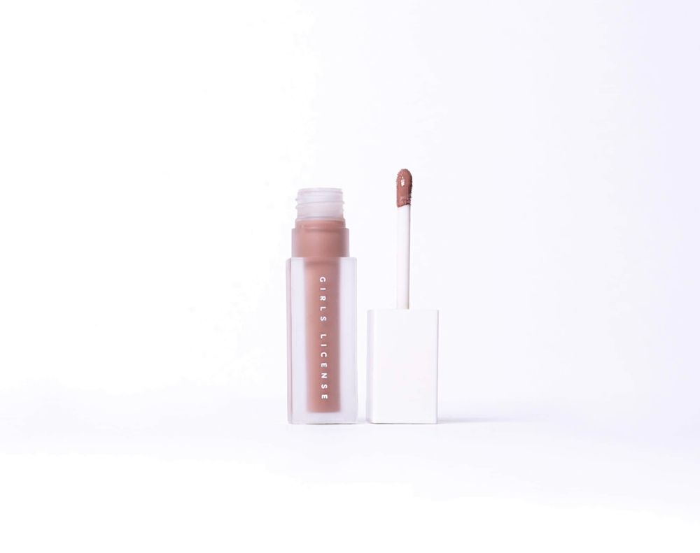 Fenty Beauty nude lip gloss with applicator wand on white background, showcasing a sheer mauve-brown shade.