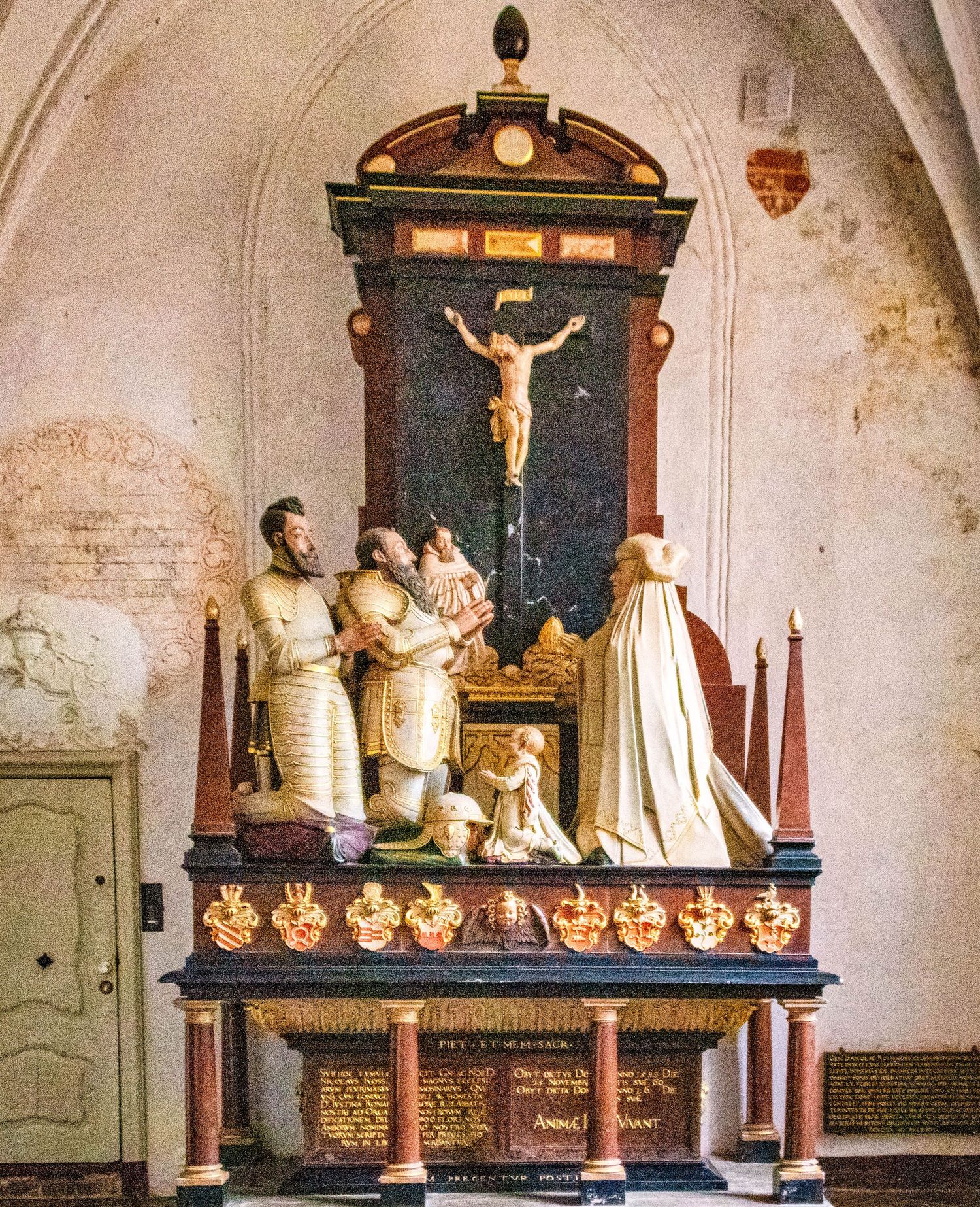 Historic church interior displaying ornate religious sculptures and artifacts arranged on decorative wooden shelves.