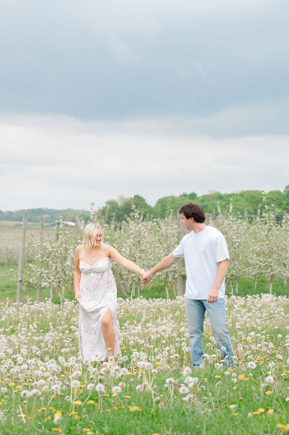 couple holding hands in field