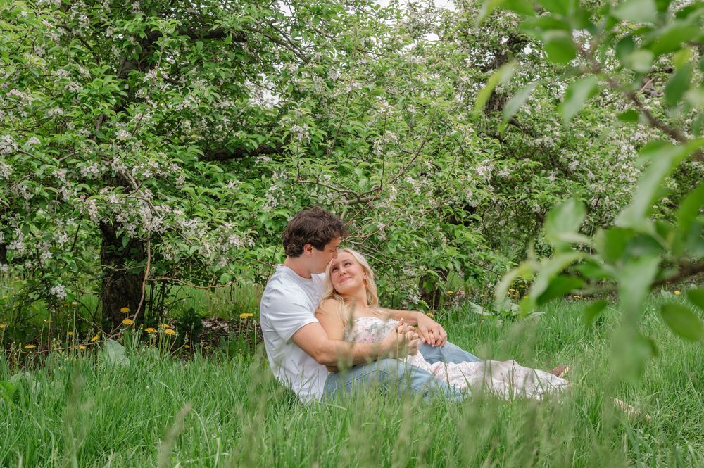 couple cuddling in between trees
