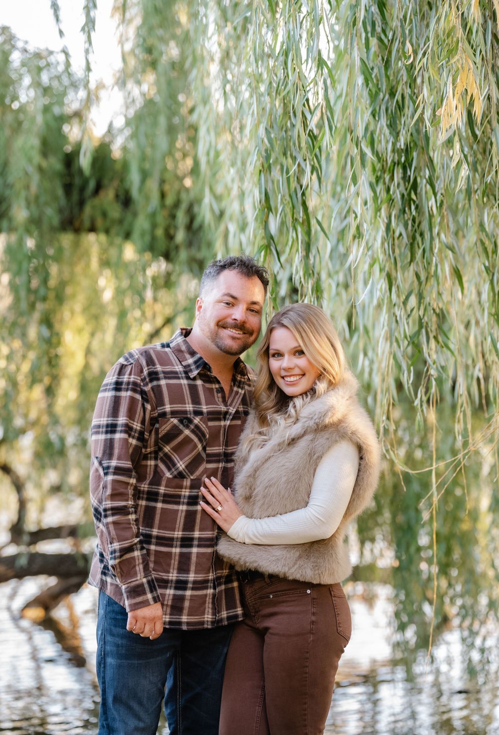 couple smiling with willow tree in background